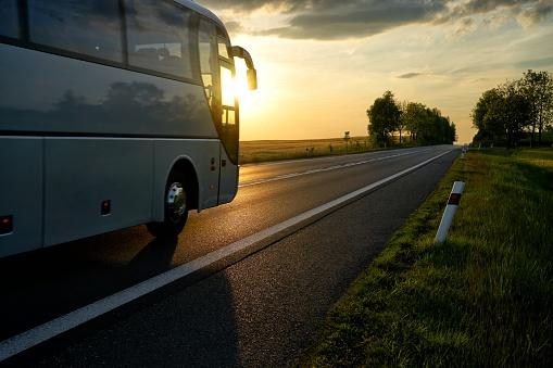 autobus na drodze w świetle zachodzącego słońca